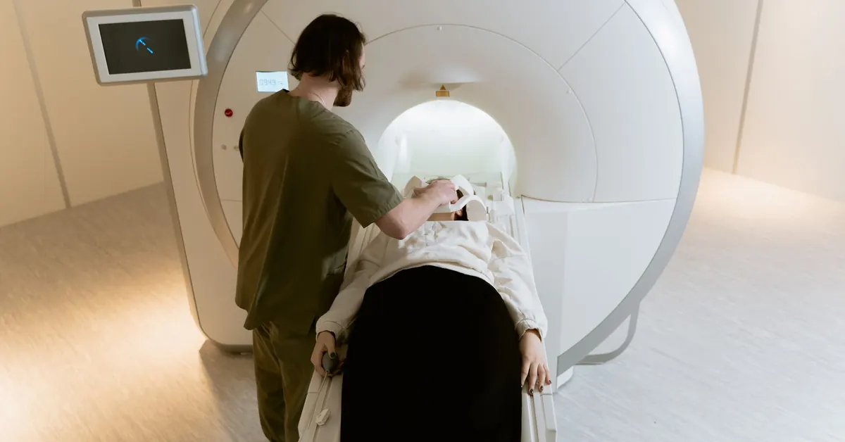 Technician positioning a patient on the table of an MRI scanner