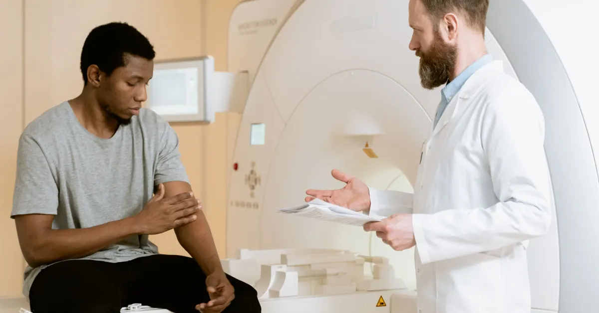 Doctor talking with a patient next to an MRI scanner