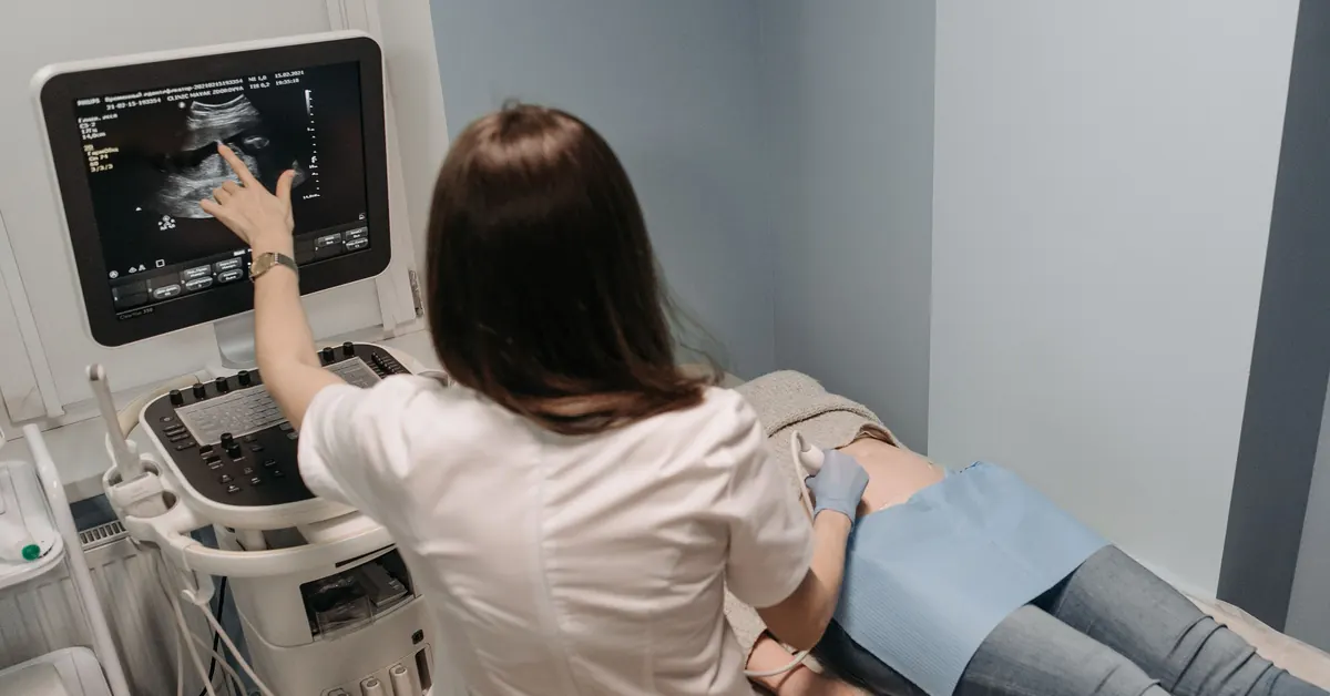 Médica realizando un ultrasonido abdominal a una paciente