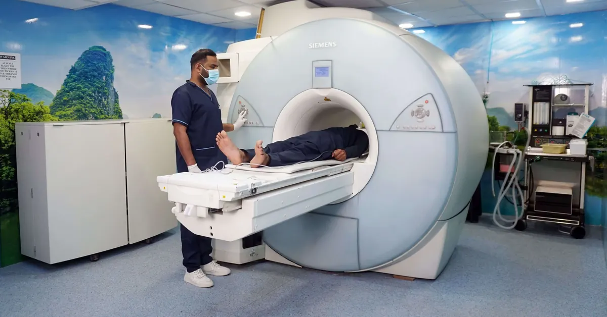 An MRI scanner with a technician preparing a patient for the exam